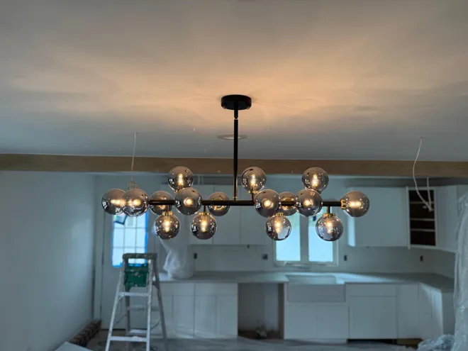 White kitchen & chandelier — Statement lighting during installation