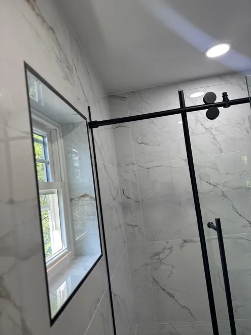 Tub surround & black fixtures — Glass enclosure detail